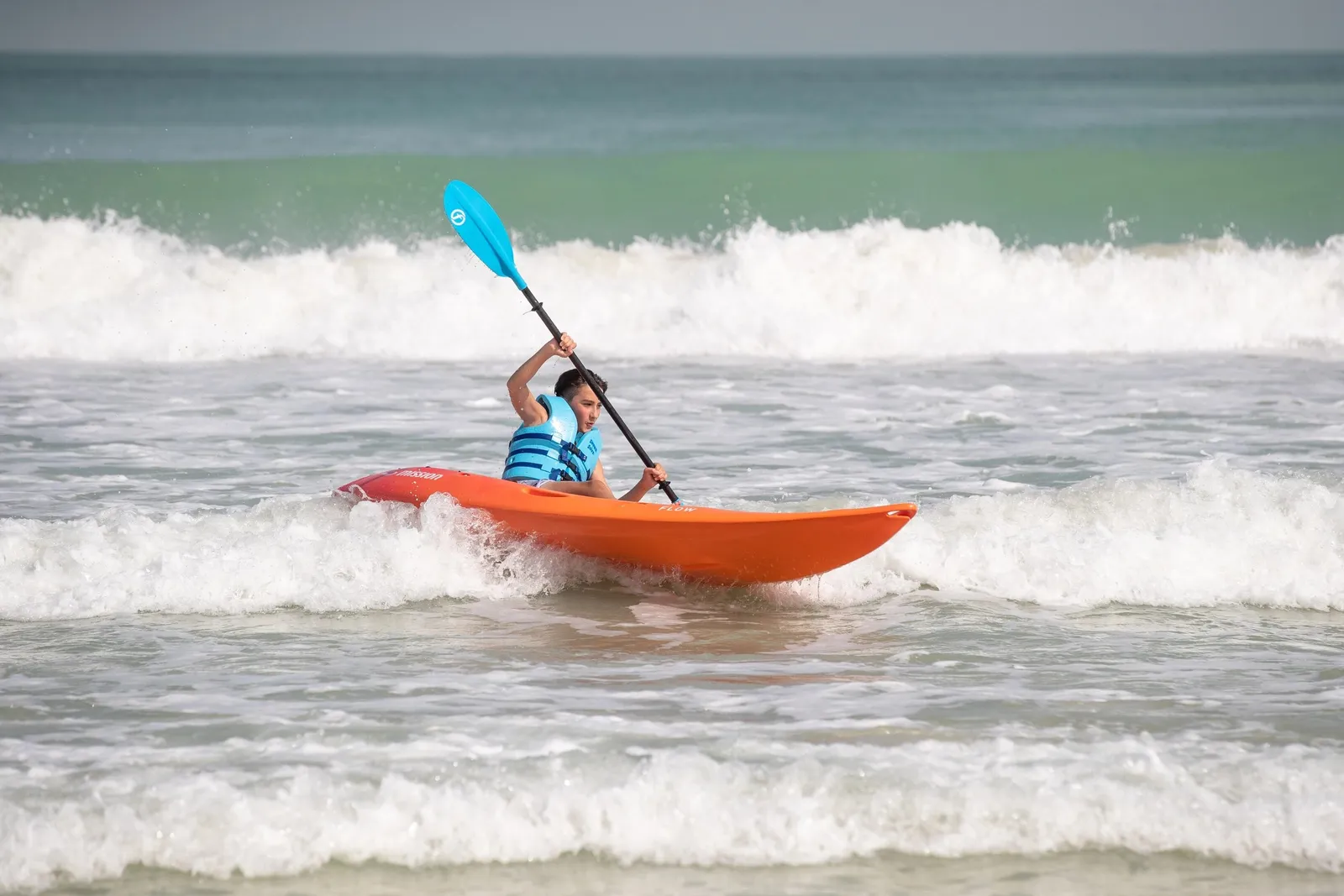A child kayaking in the waves
