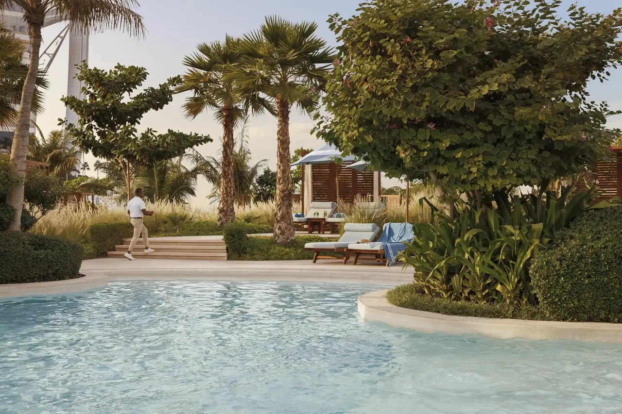 A pool among palms and garden pavilions
