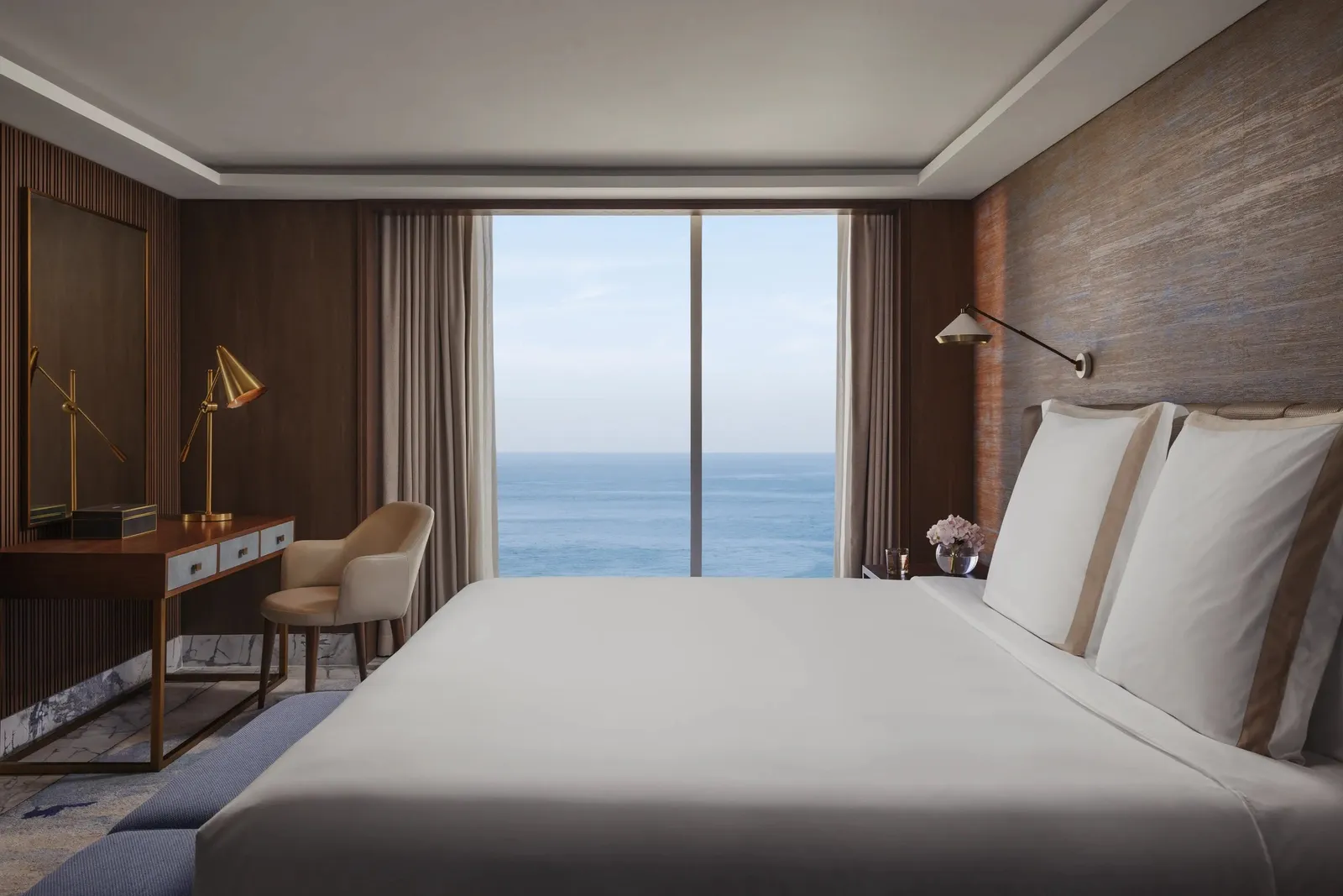 The Al Marsa Suite bedroom with the sea beyond the glass