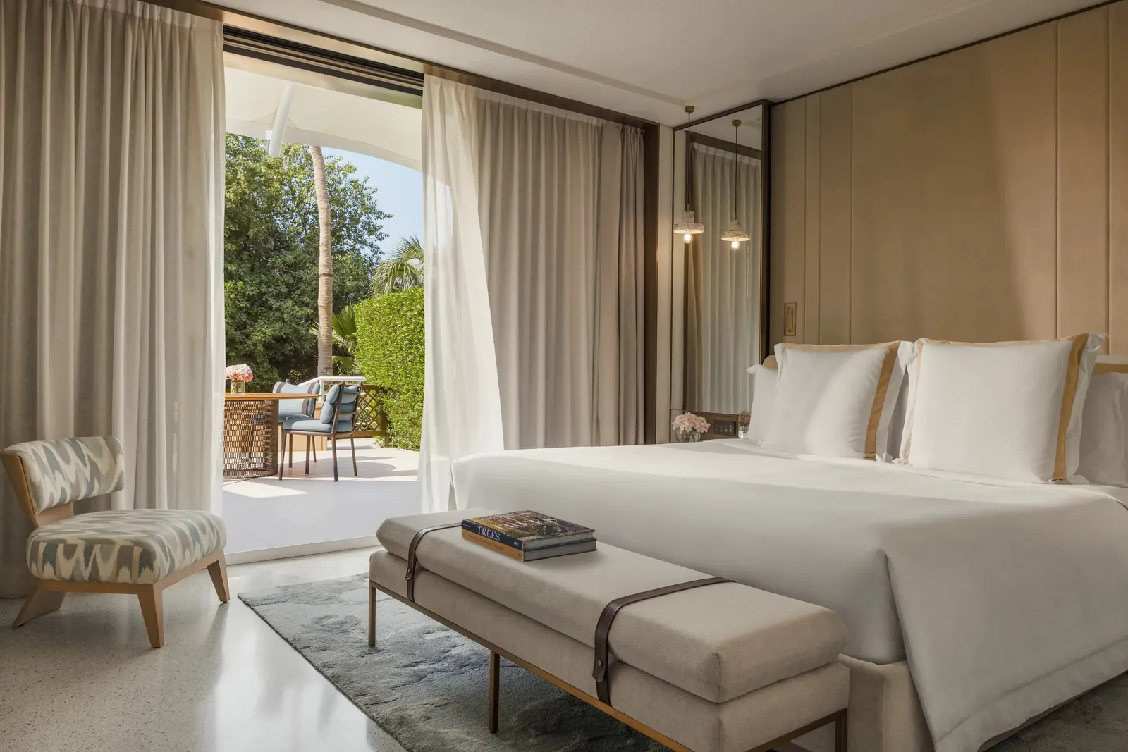 A room with a king bed and the door open onto the garden