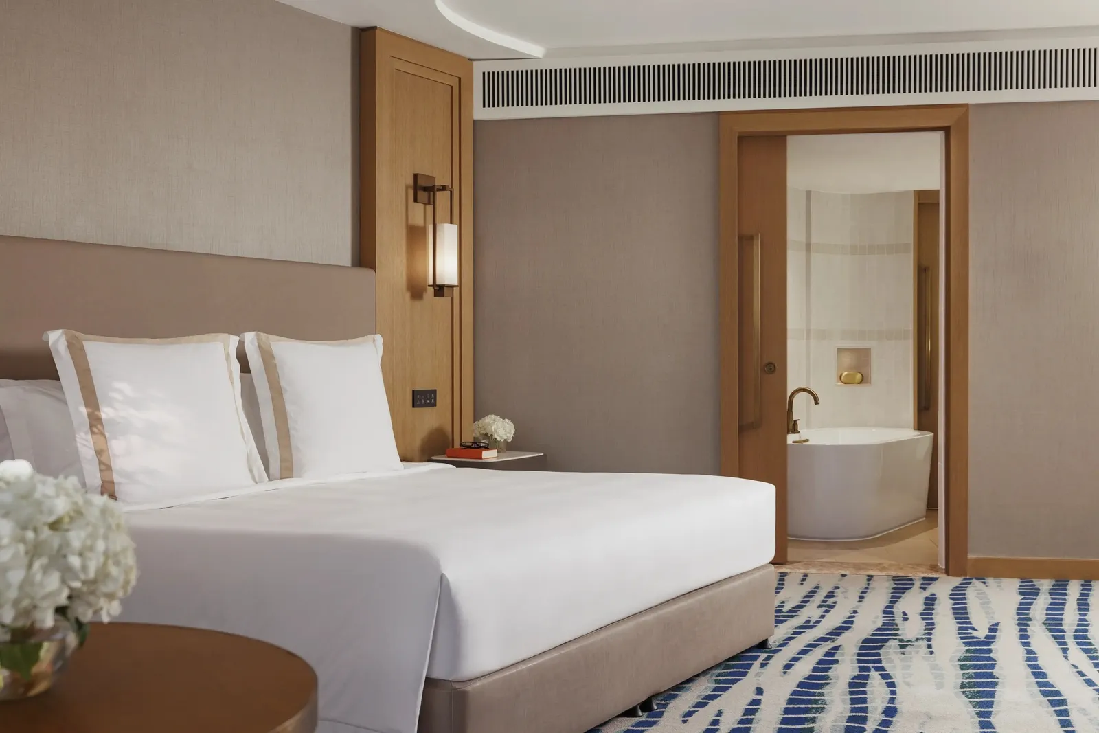 A room with a king bed and the bath beyond the sliding door