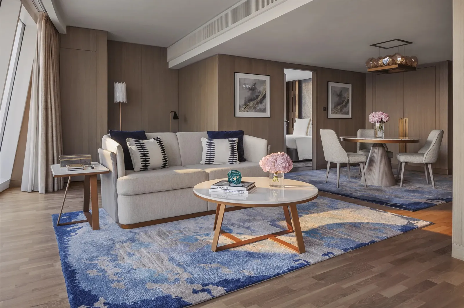 A suite living room with a pale sofa and a blue rug