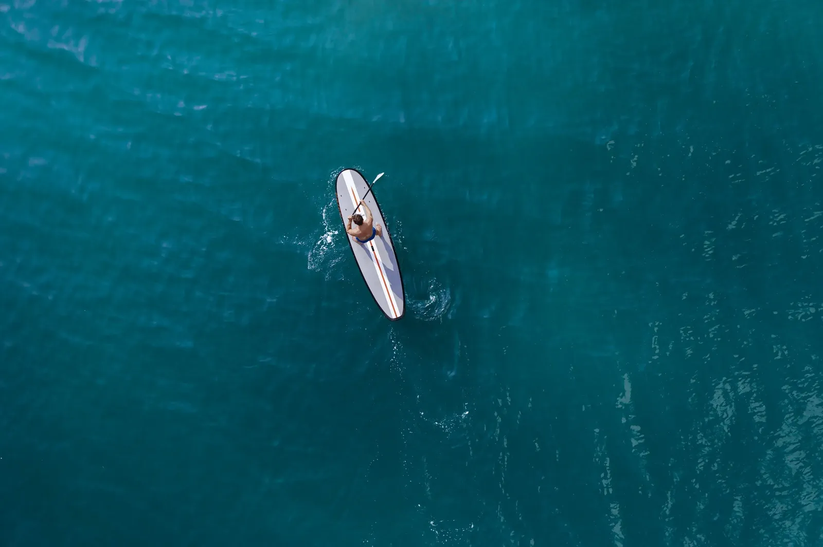 A paddleboard on the blue sea from above