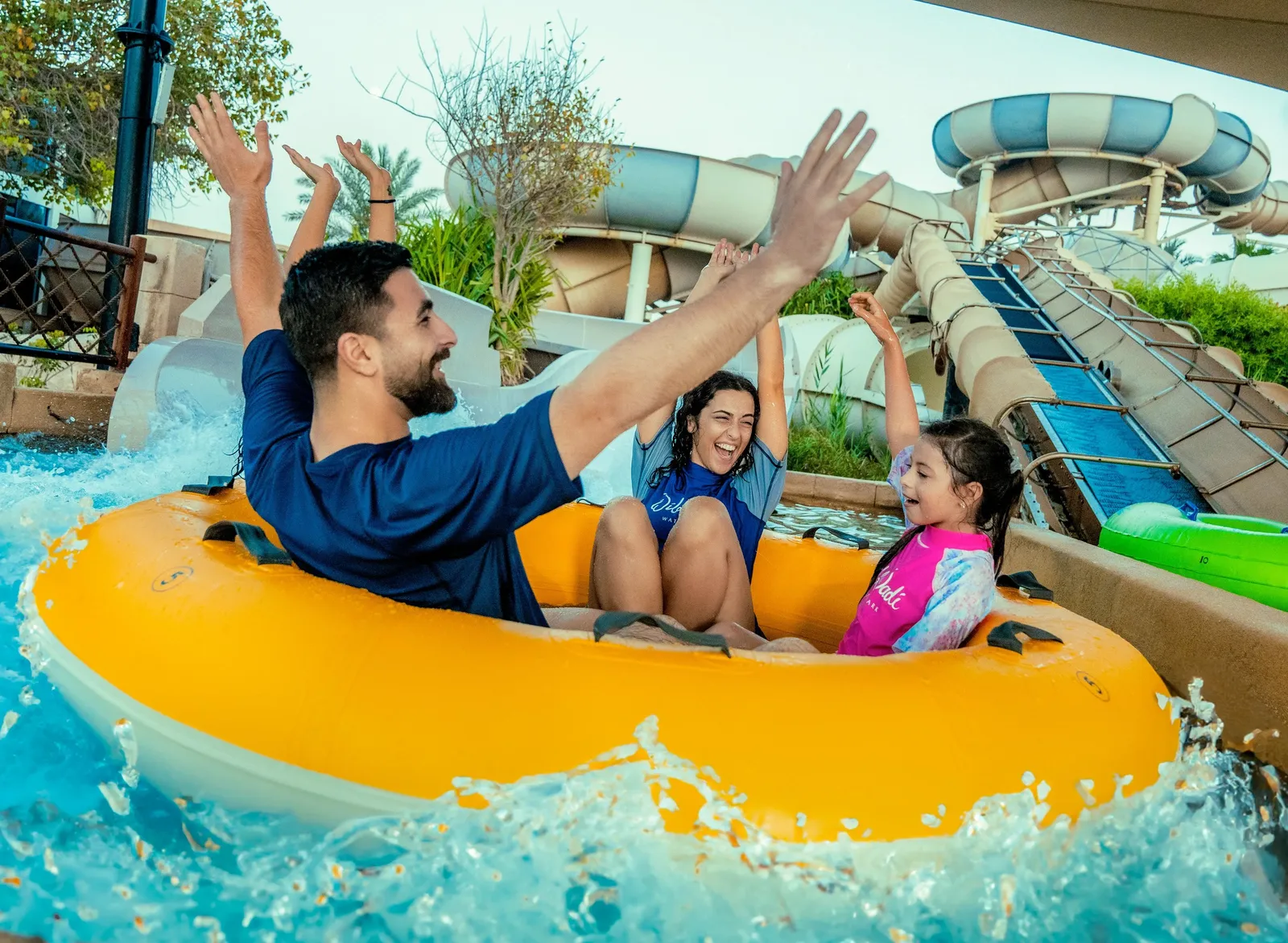 A family on a yellow raft on a Wild Wadi slide