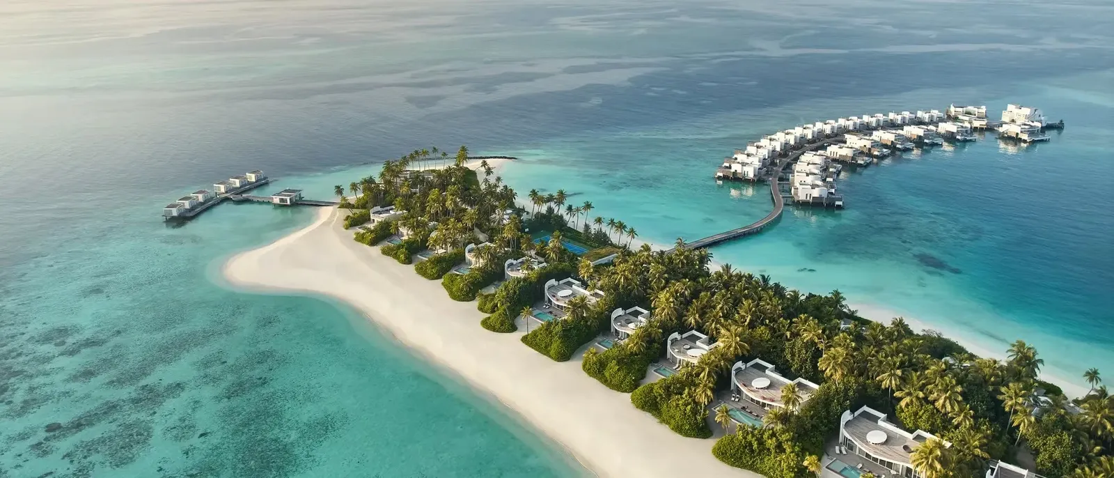 Olhahali from the air: the sandbar, the villas among the palms and the jetties of the water villas