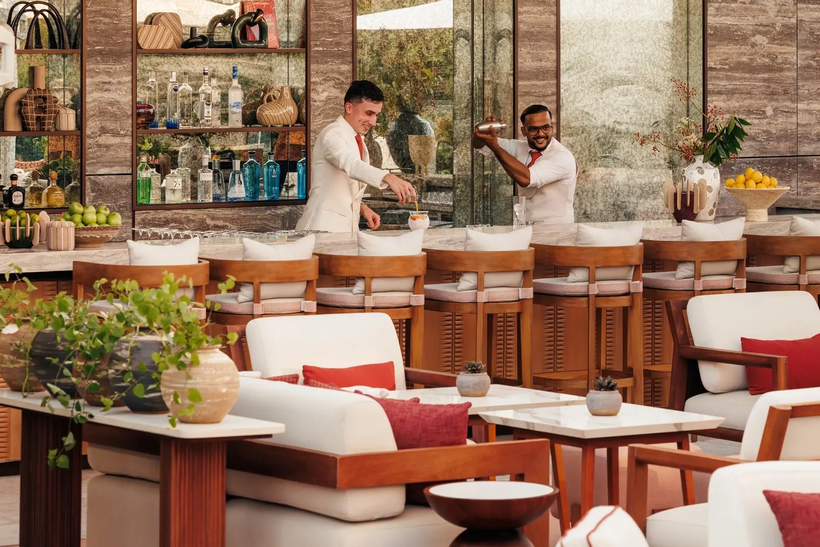 A bar counter with bartenders and high stools