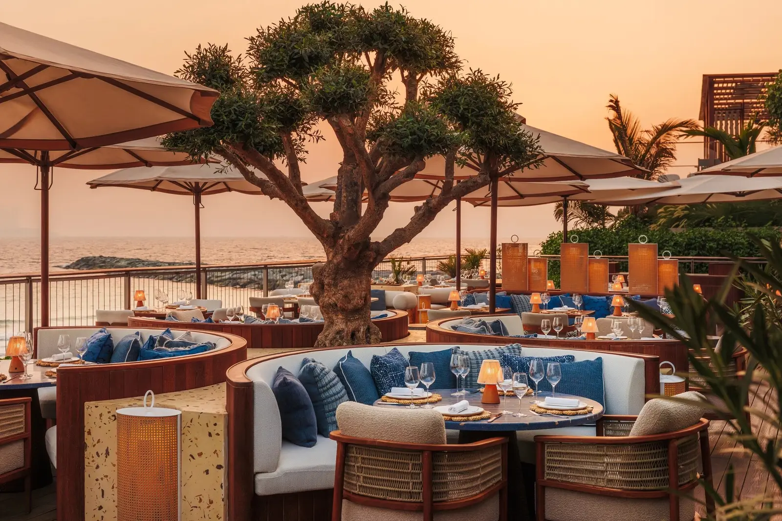 Iliana’s beachfront terrace under parasols at sunset