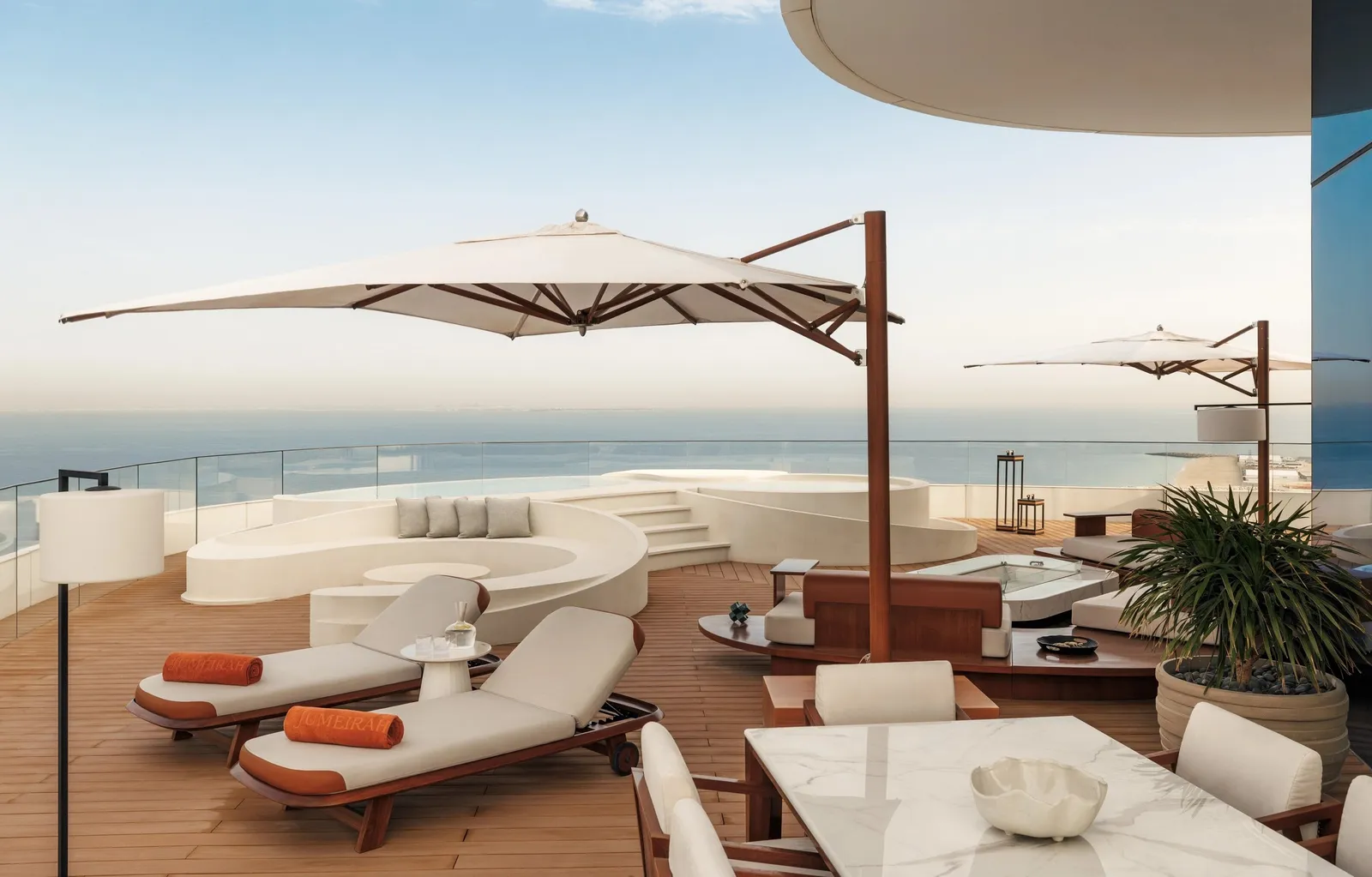 A terrace with parasols and loungers above the sea