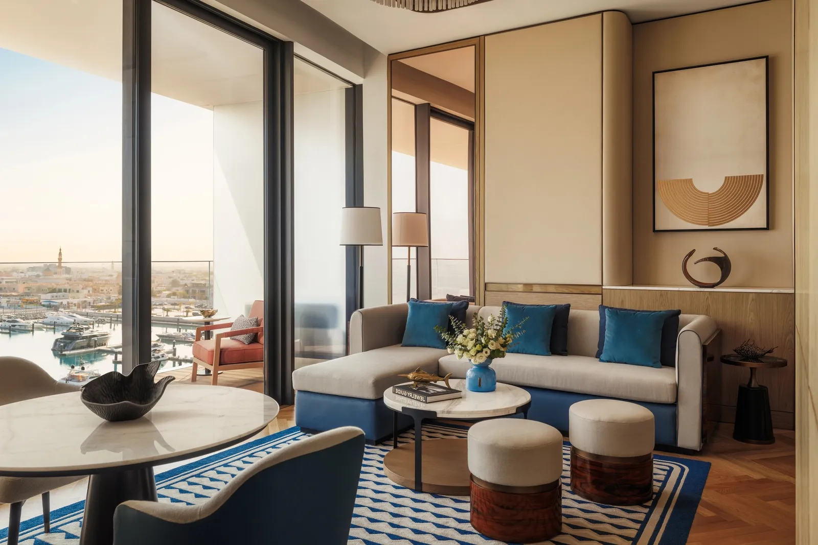 A sitting room with a blue sofa and glass walls on the marina