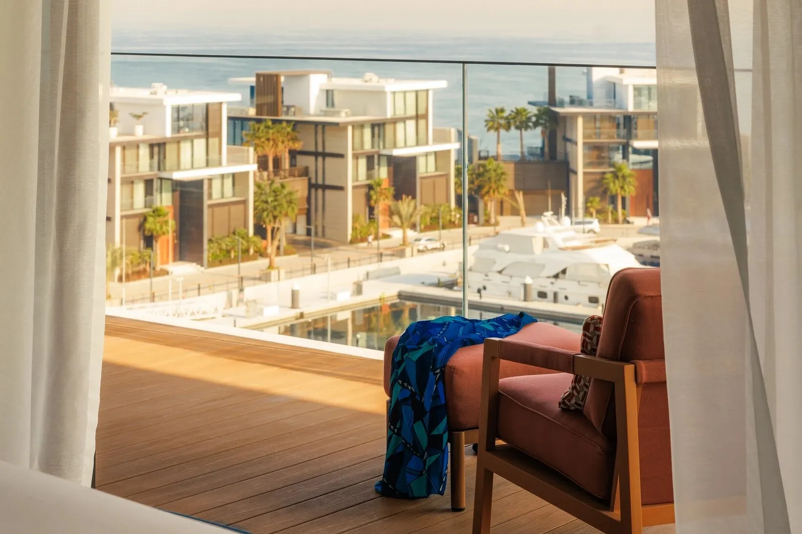 A terrace with red armchairs above the marina