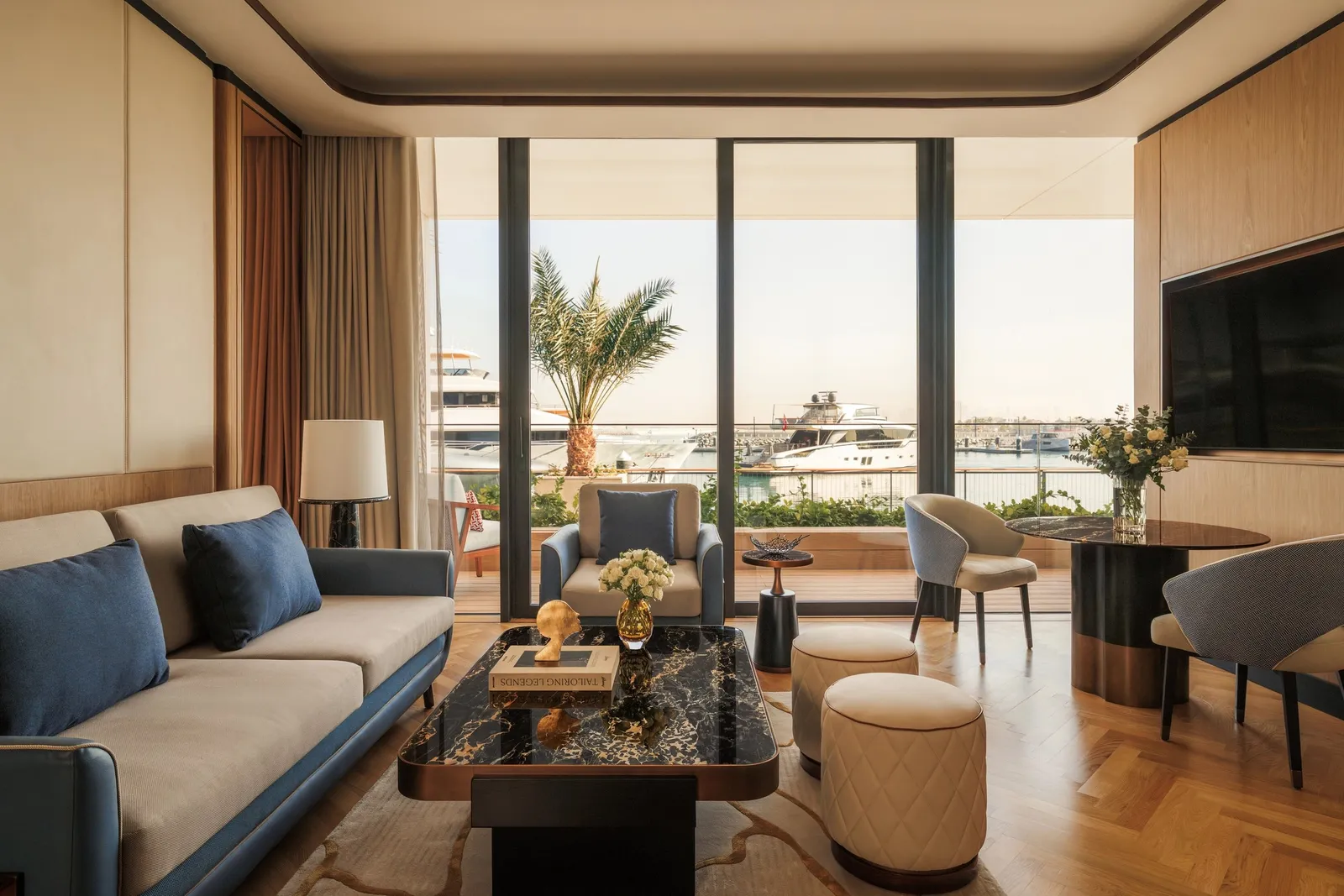 A sitting room with blue sofas and the marina beyond