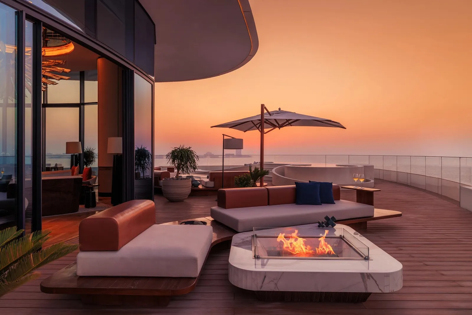 A suite terrace with a fire table at sunset