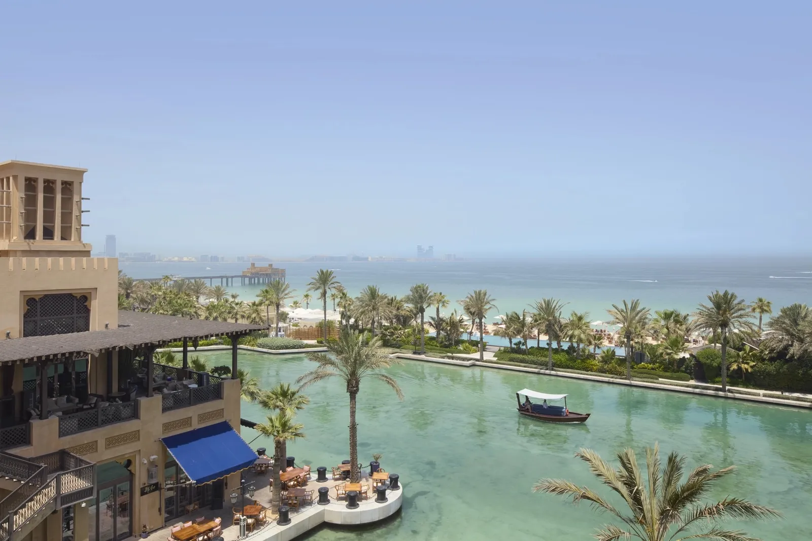 The waterway with abra boats, palms and the sea from a Deluxe Ocean room