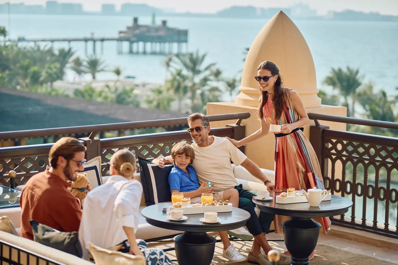 A family on the Amal Lounge terrace, with the sea behind