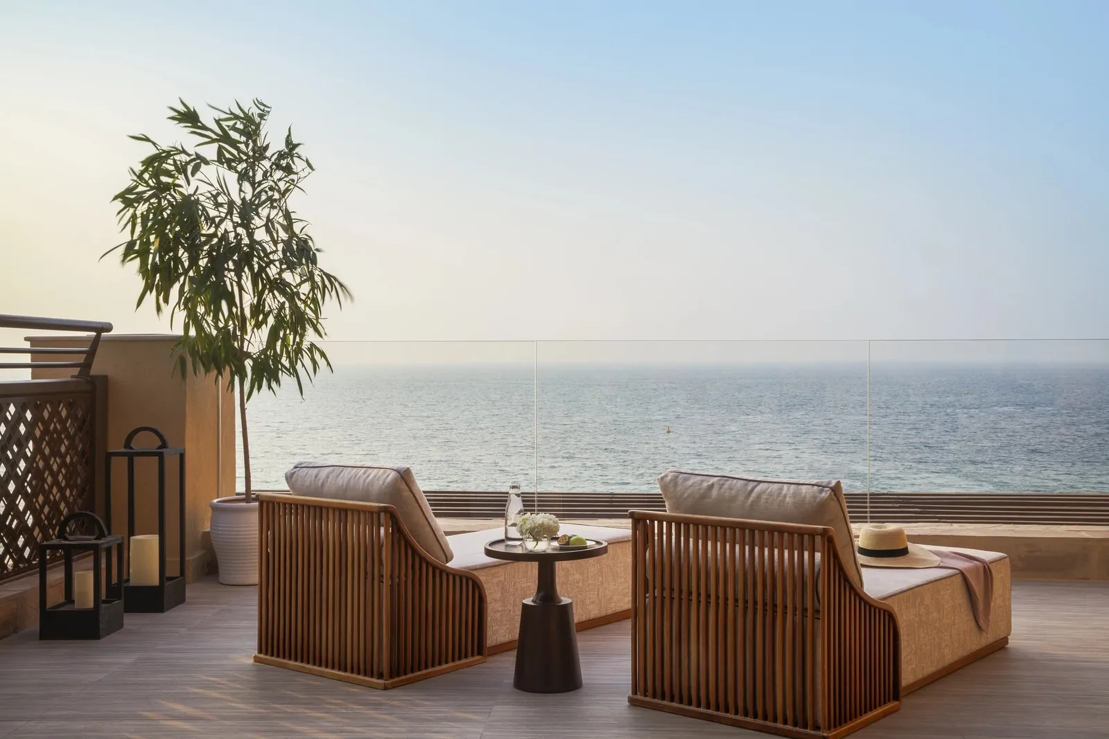 Wooden armchairs on the sea-facing terrace of the One-Bedroom Terrace Ocean Suite