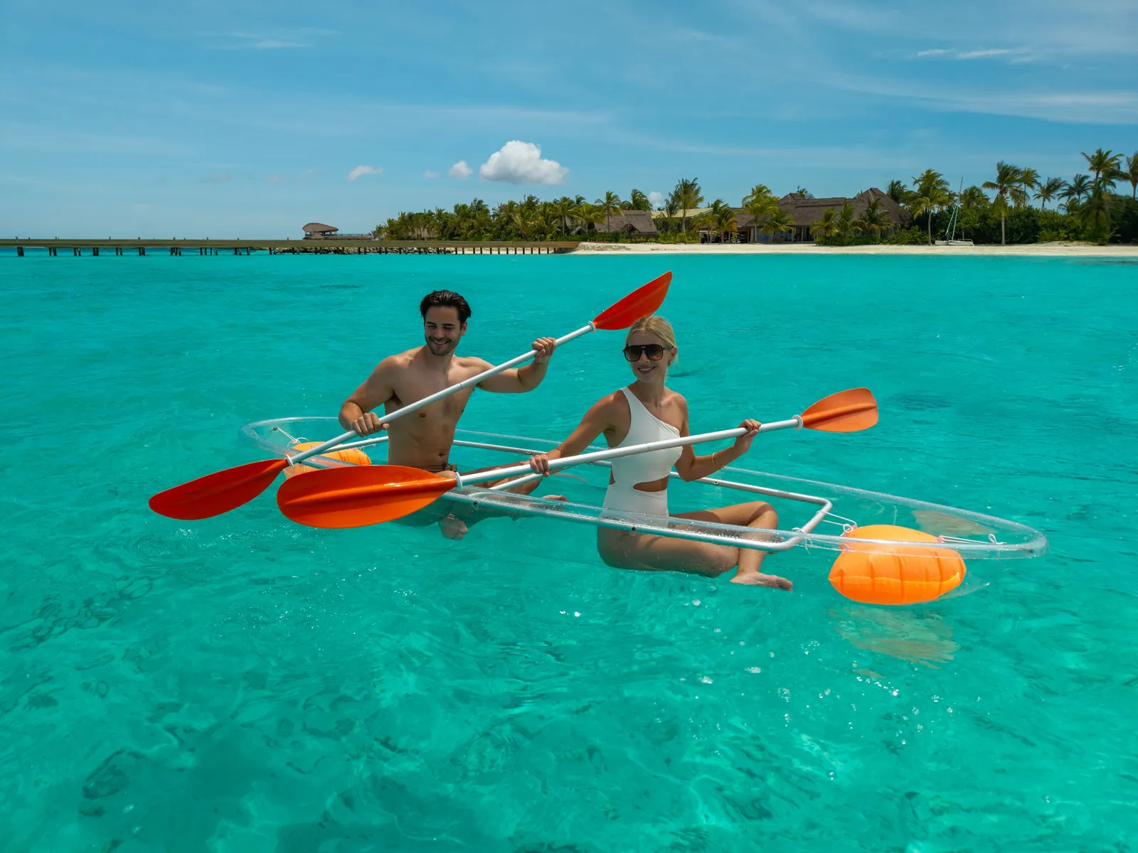A couple in a clear kayak on the lagoon