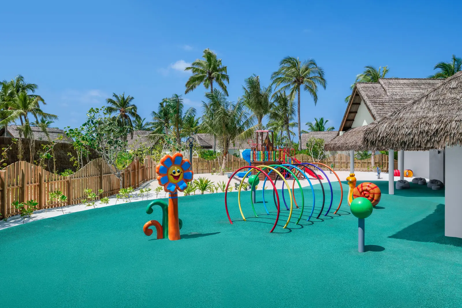 The kids’ club splash park, its coloured sprays and the palms