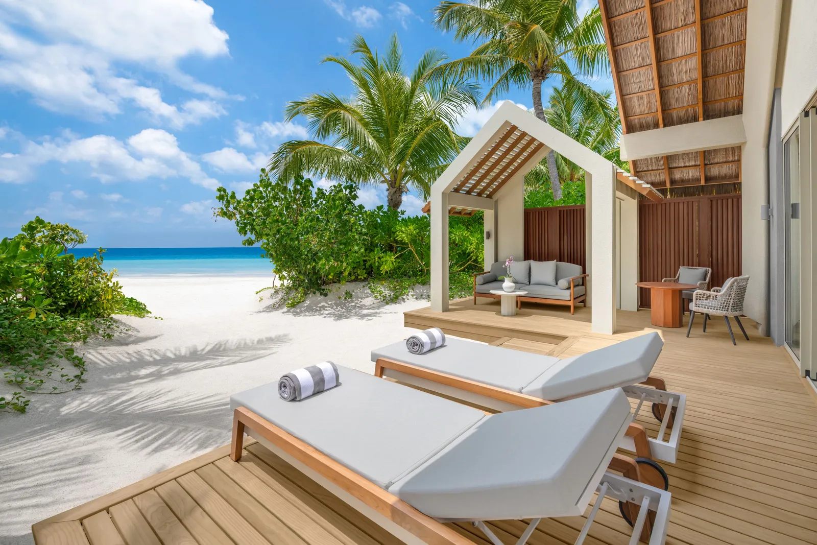 The Family Beach Pool Villa’s deck, loungers and gazebo on the sand