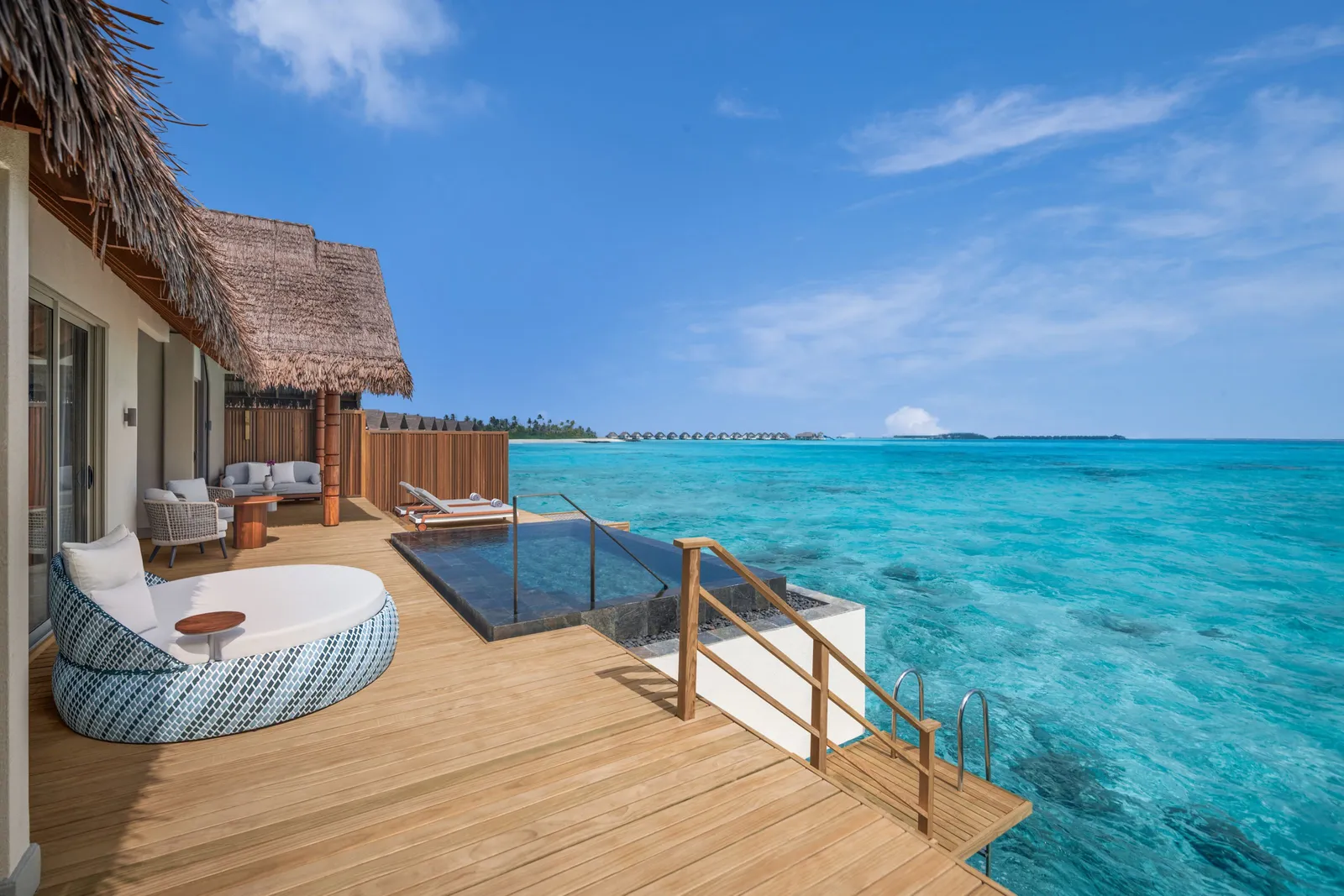 An Overwater Pool Villa’s deck, its infinity pool over the sea