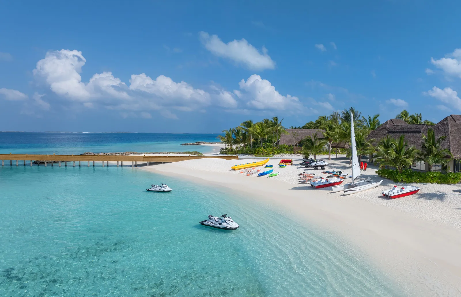 The watersports beach from above, with jet skis and catamarans