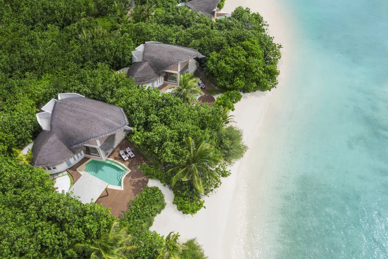 2 beach villas from above, their pools screened by greenery