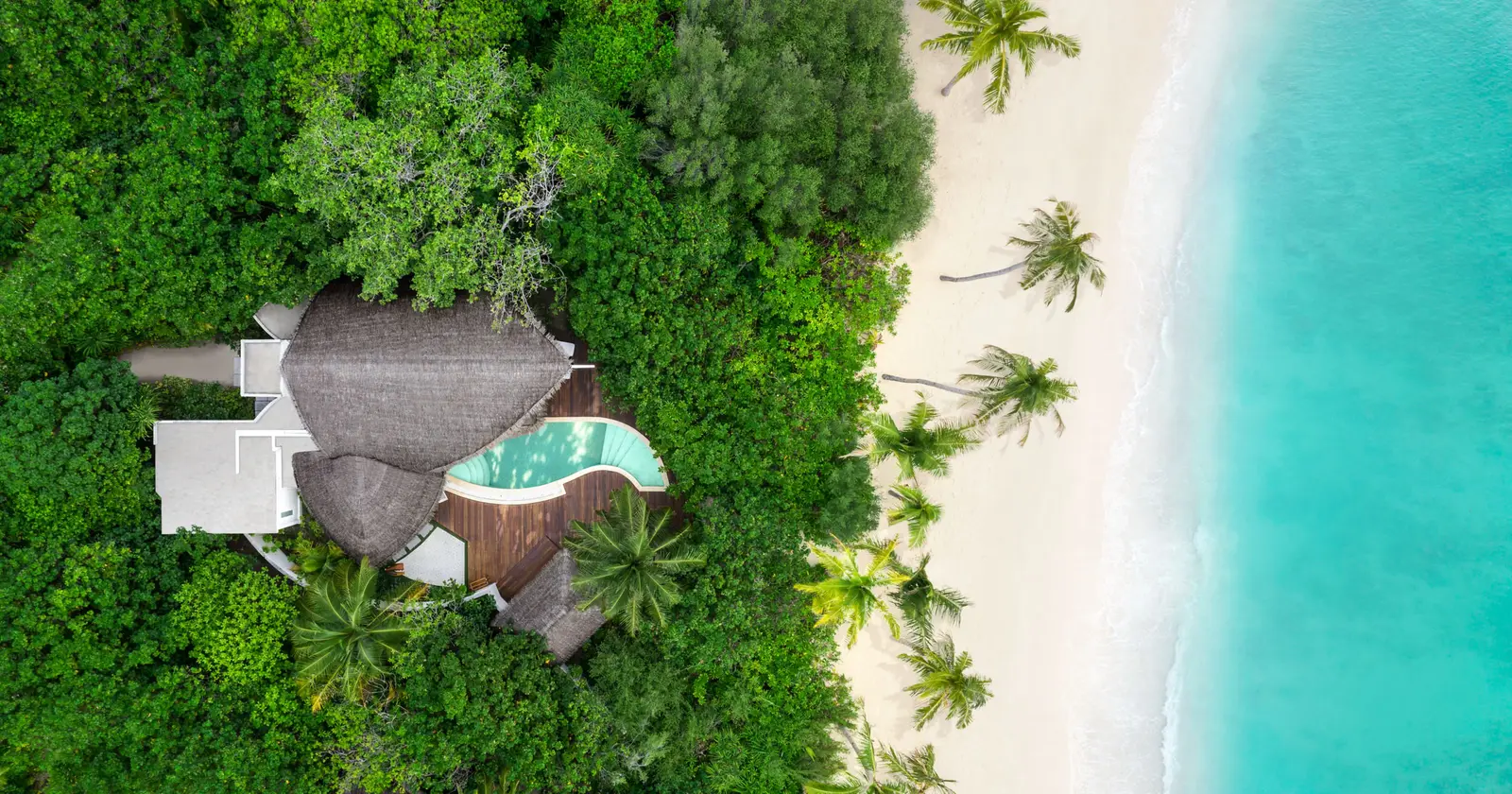The Two-Bedroom Duplex Beach Pool Villa from above, its pool in the garden and the beach beside it