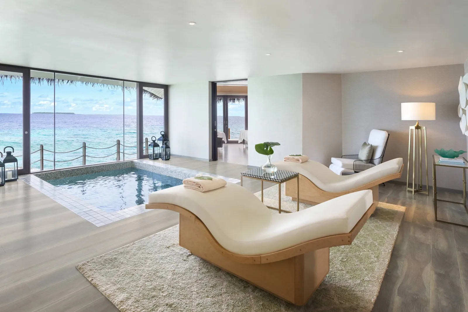The spa suite, its bath and loungers before the windows on the sea