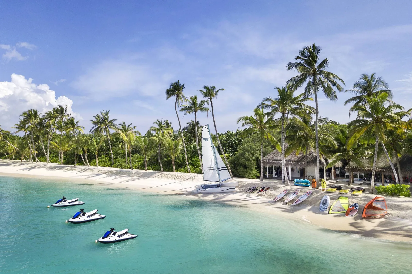 Jet skis and a catamaran off the beach of the watersports centre