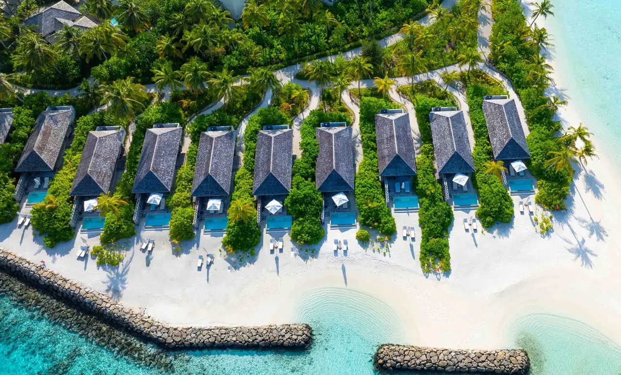 The Beach Pool Villas from above, in a row between the greenery and the beach