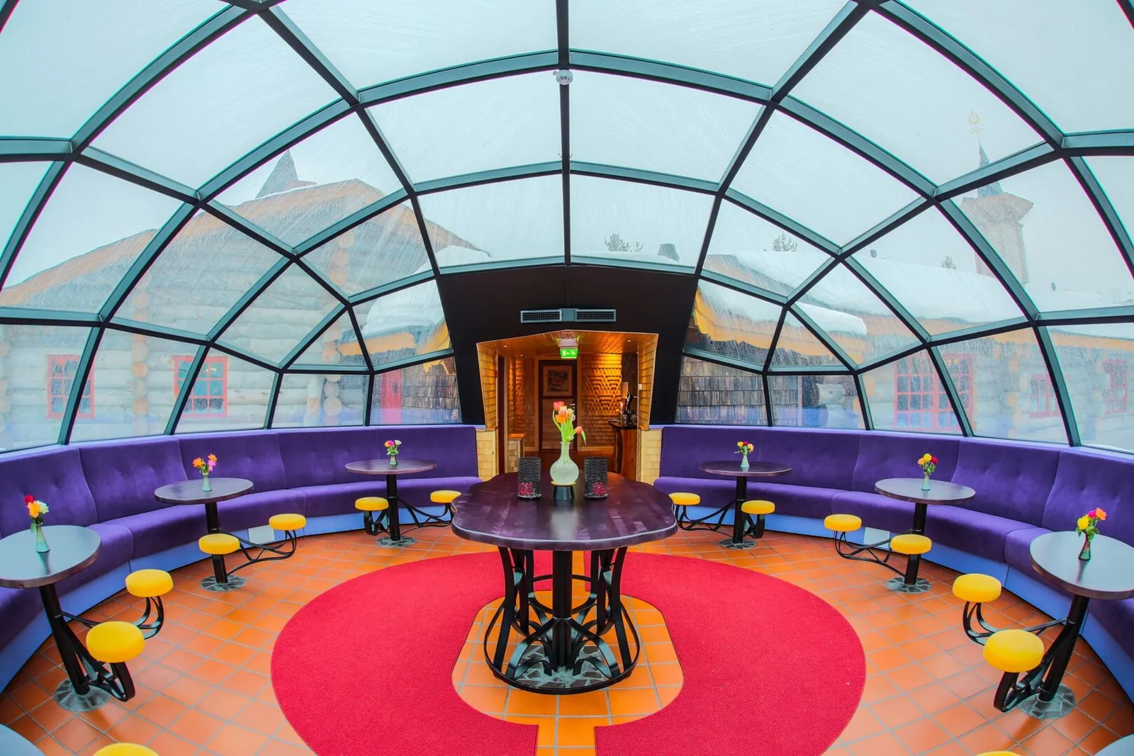 The Igloo Bar: under the glass dome, the circular purple banquette, small tables and yellow stools round a red carpet.