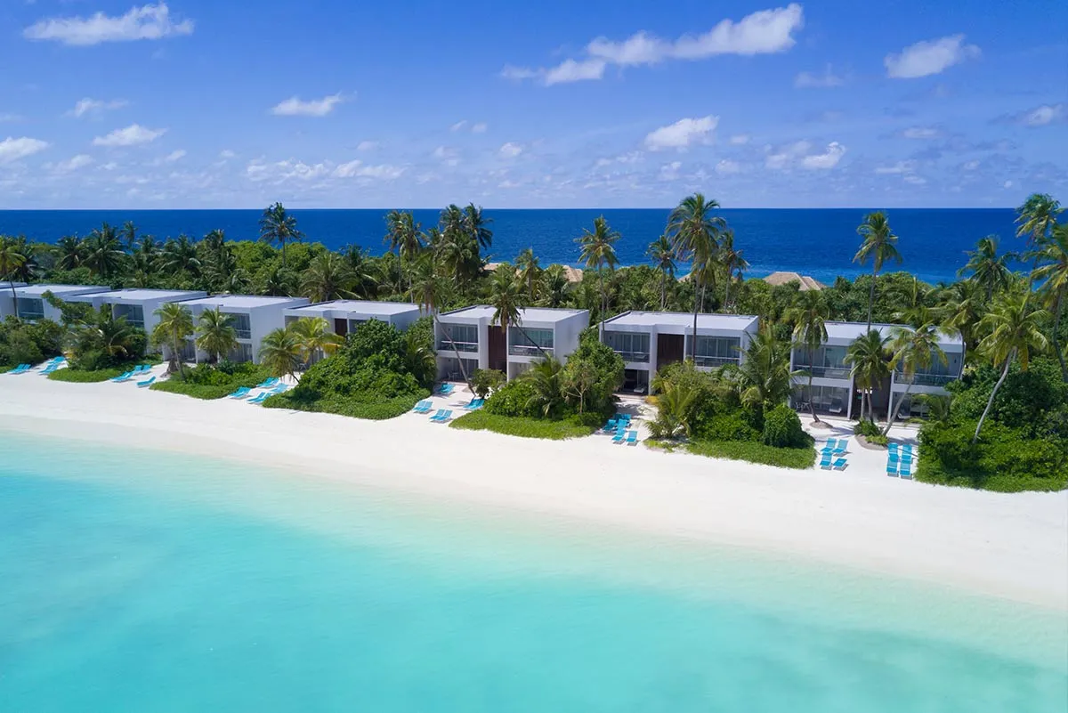 The beach villas from the air, between the greenery and the white sand