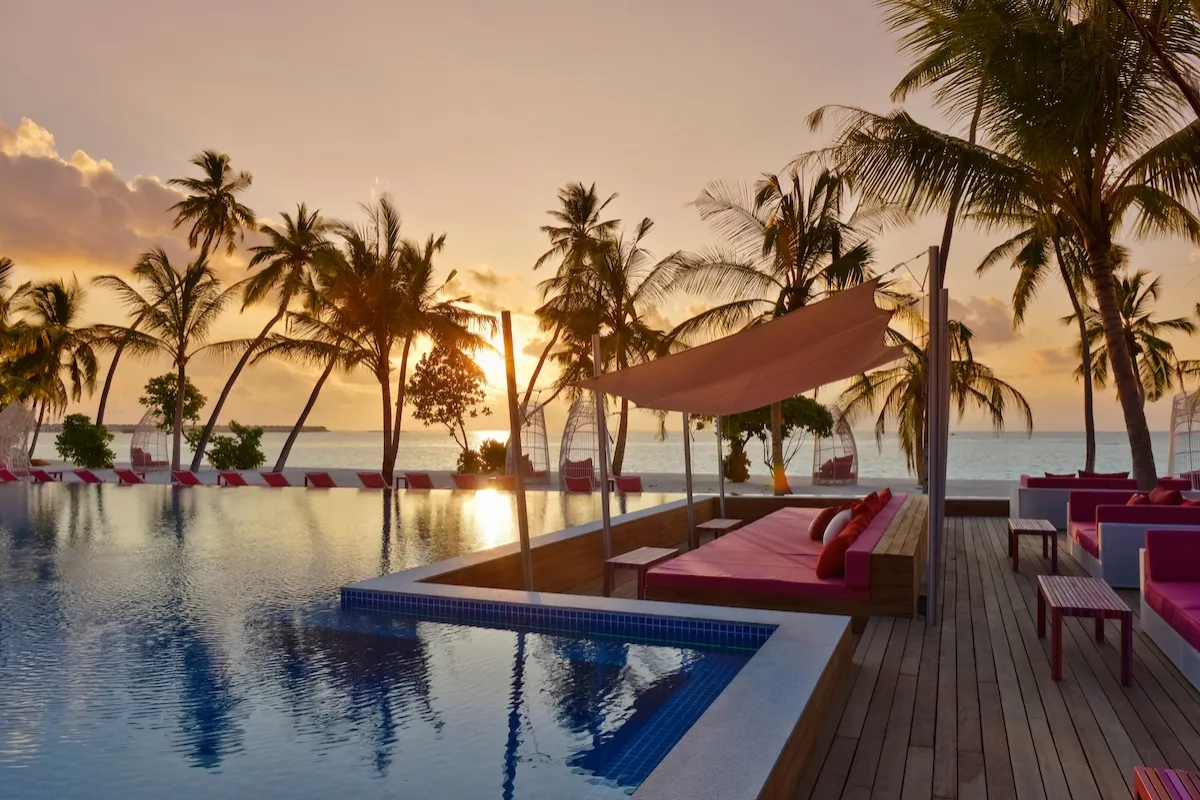 The Breeze pool at sunset, among the palms