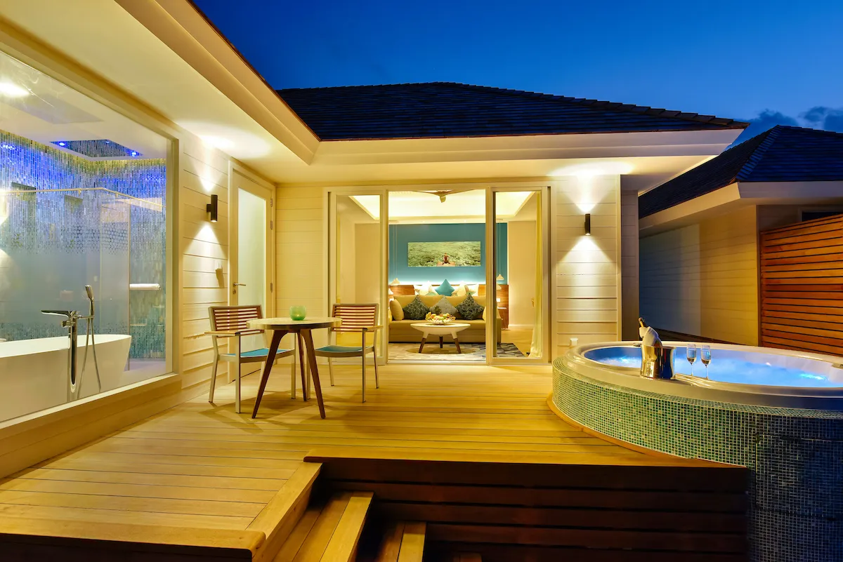 An Aqua Villa with Swirl Pool’s deck at dusk, its whirlpool tub lit