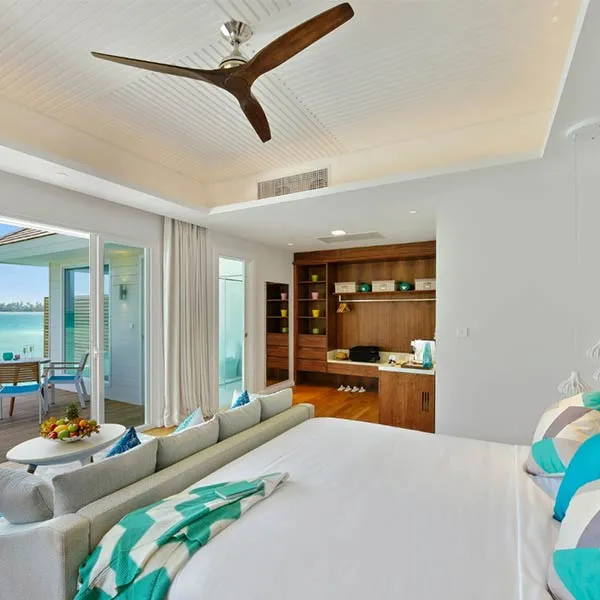 An Aqua Villa bedroom, its bed and windows onto the lagoon