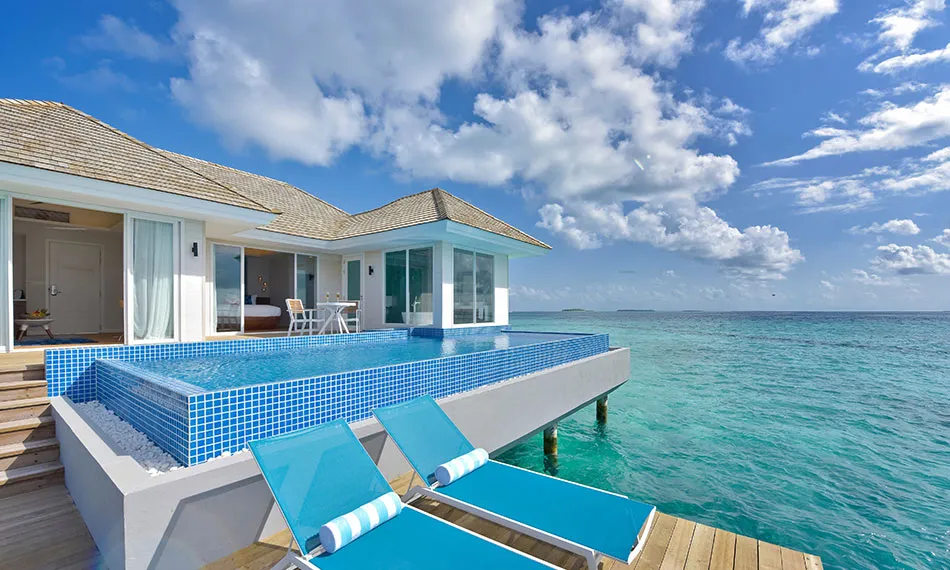 The Sunset Aqua Pool Suite, its infinity pool over the sea and blue loungers