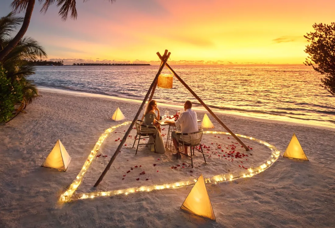 A dinner on the beach under a tipi, among candles, at sunset
