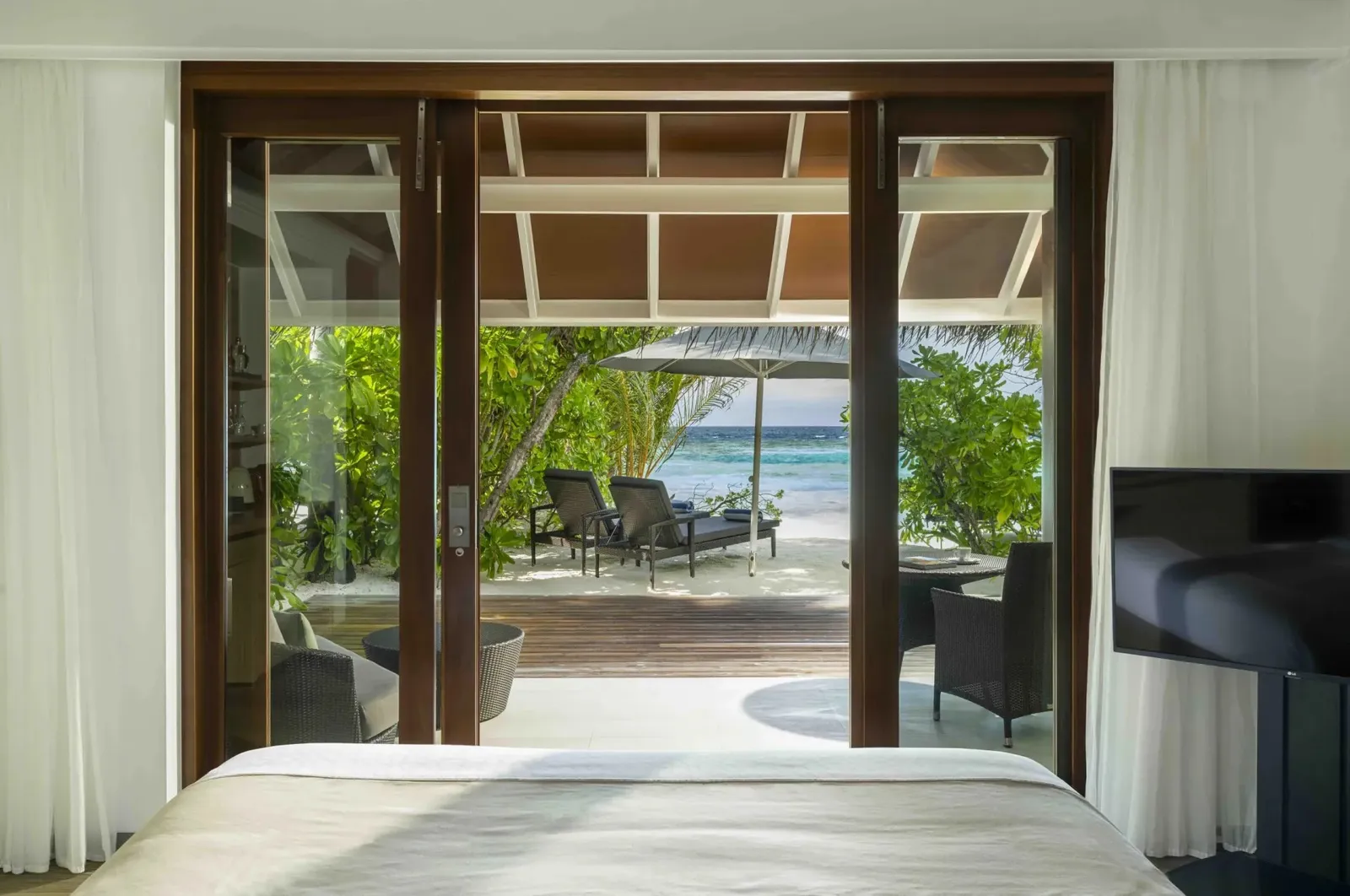 From a Beach Villa’s bedroom, the bed and the verandah open towards the beach