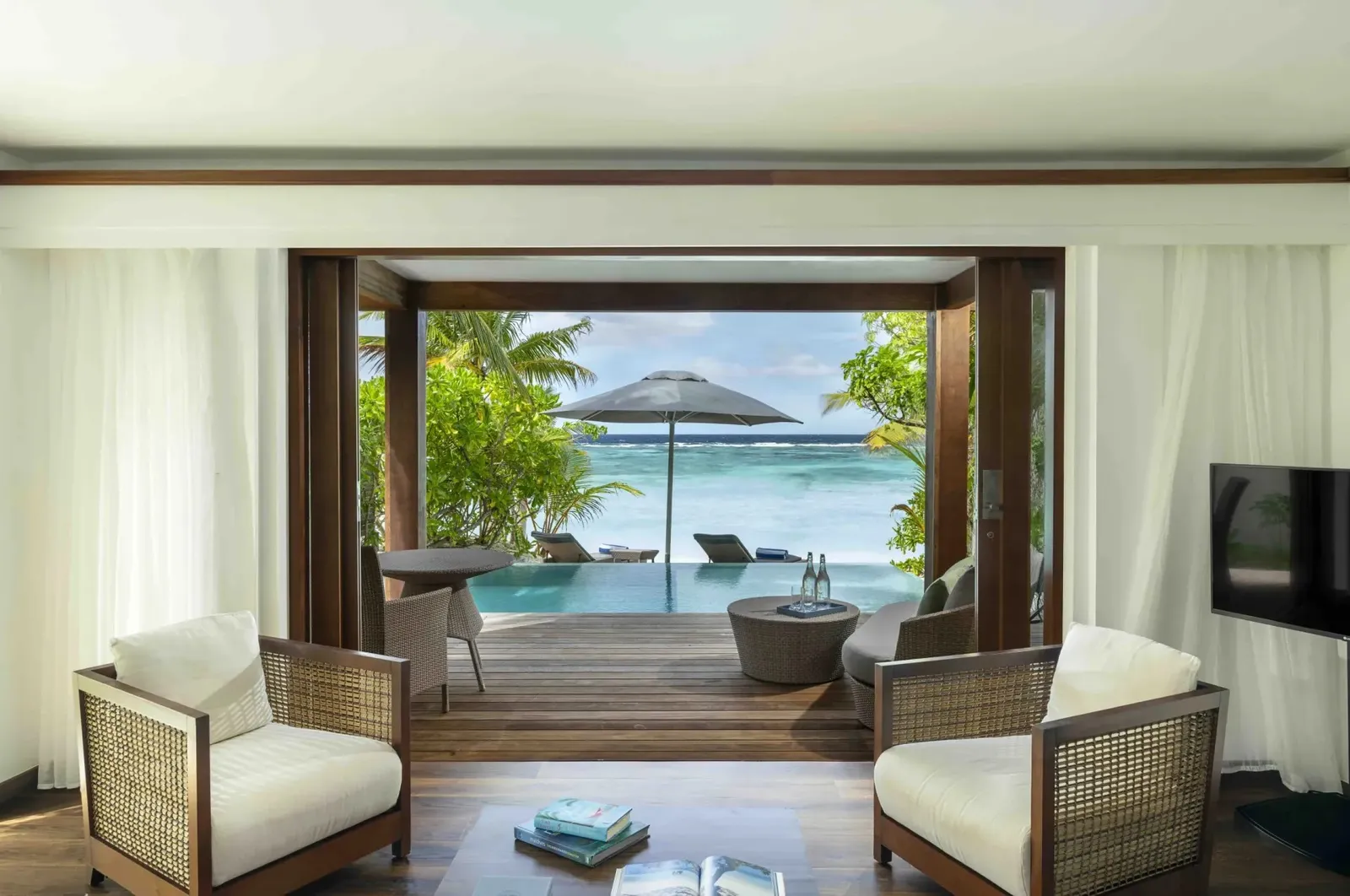 A Duplex Pool Villa’s living room, open to the pool and the beach