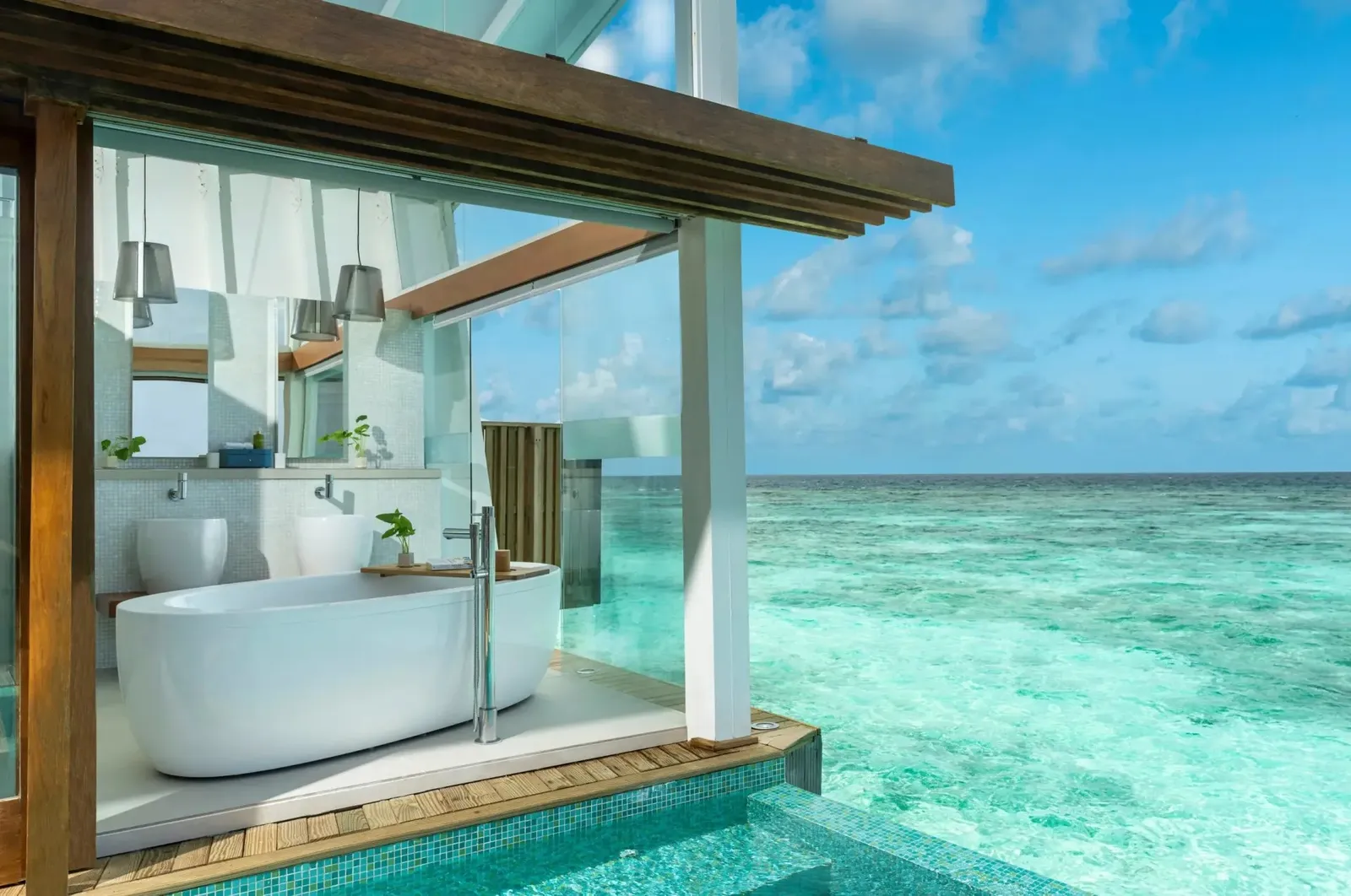An Ocean Pool Villa’s glass-walled bathroom, above the sea