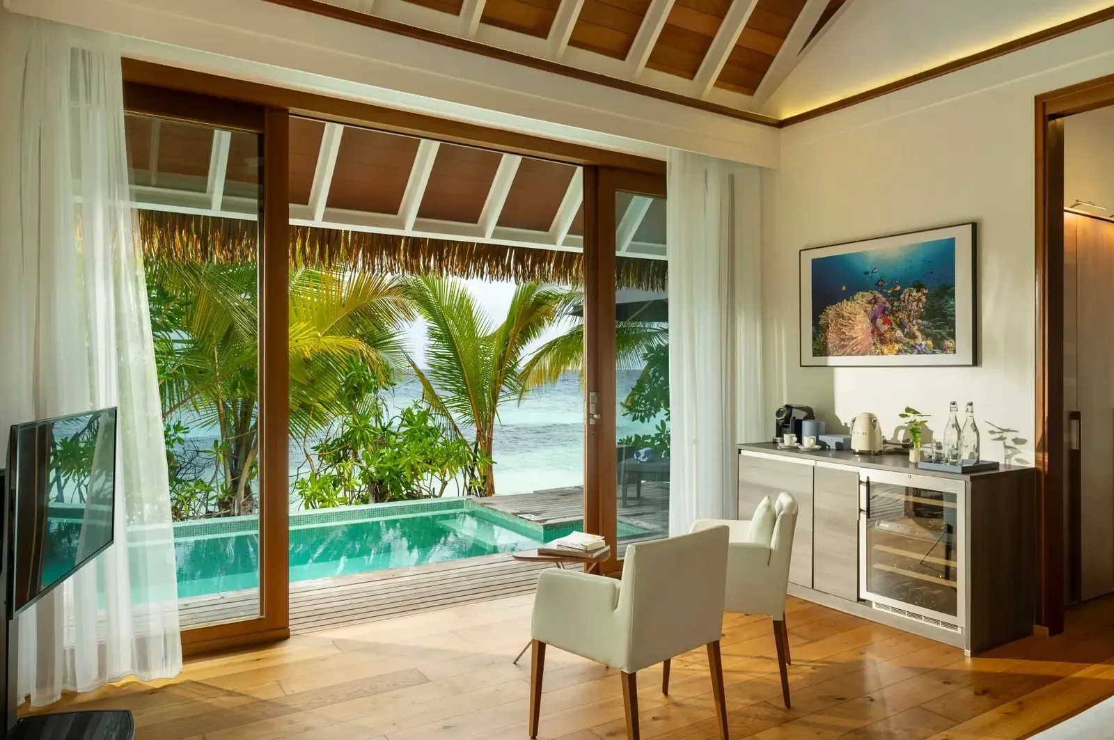 A Pool Villa: the bedroom, the pool behind the glass and the palms