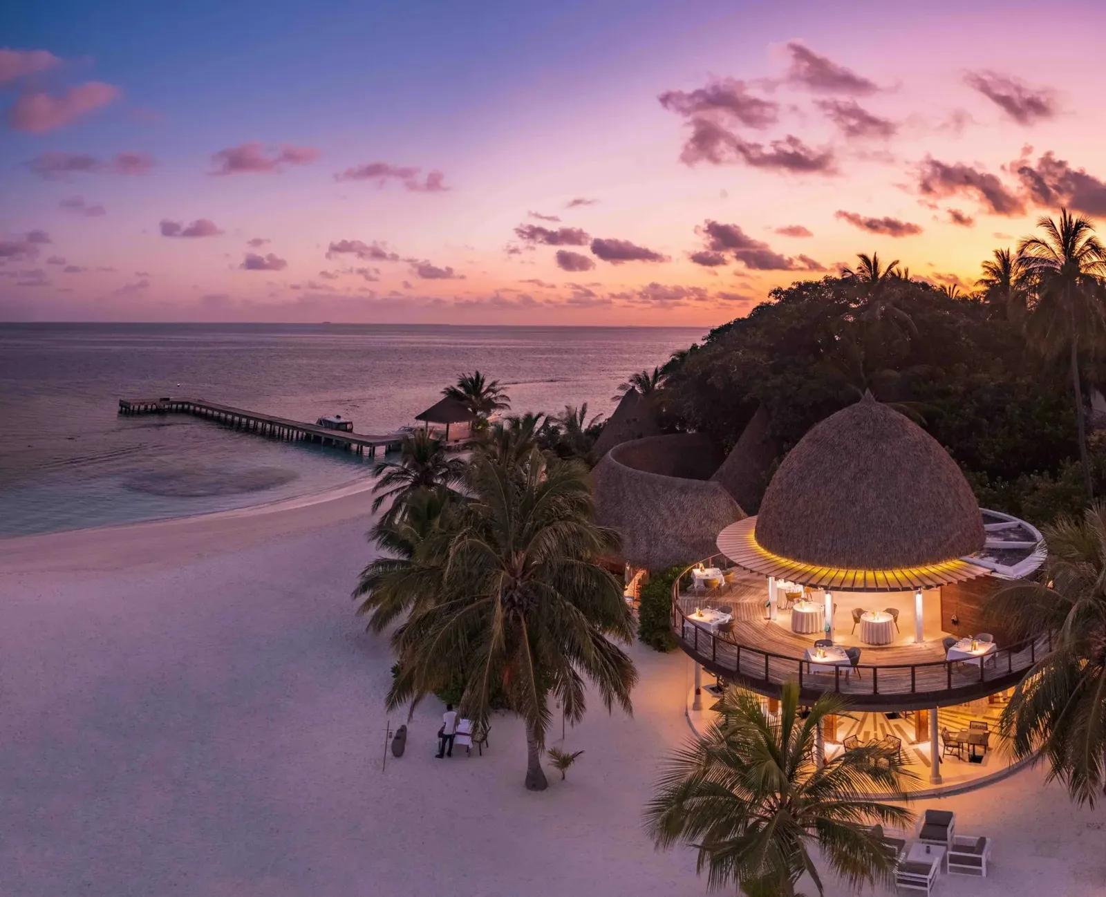 The thatched beach restaurant at sunset, seen from above, with the jetty