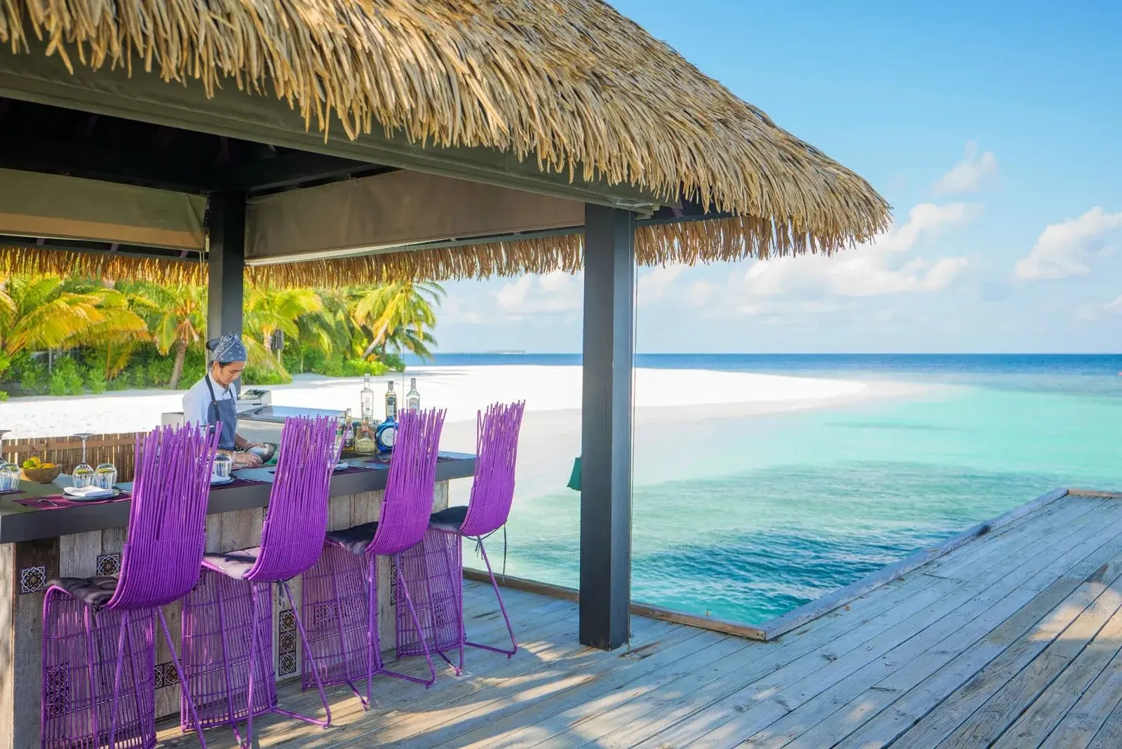 The counter over the water with its purple stools and the turquoise lagoon