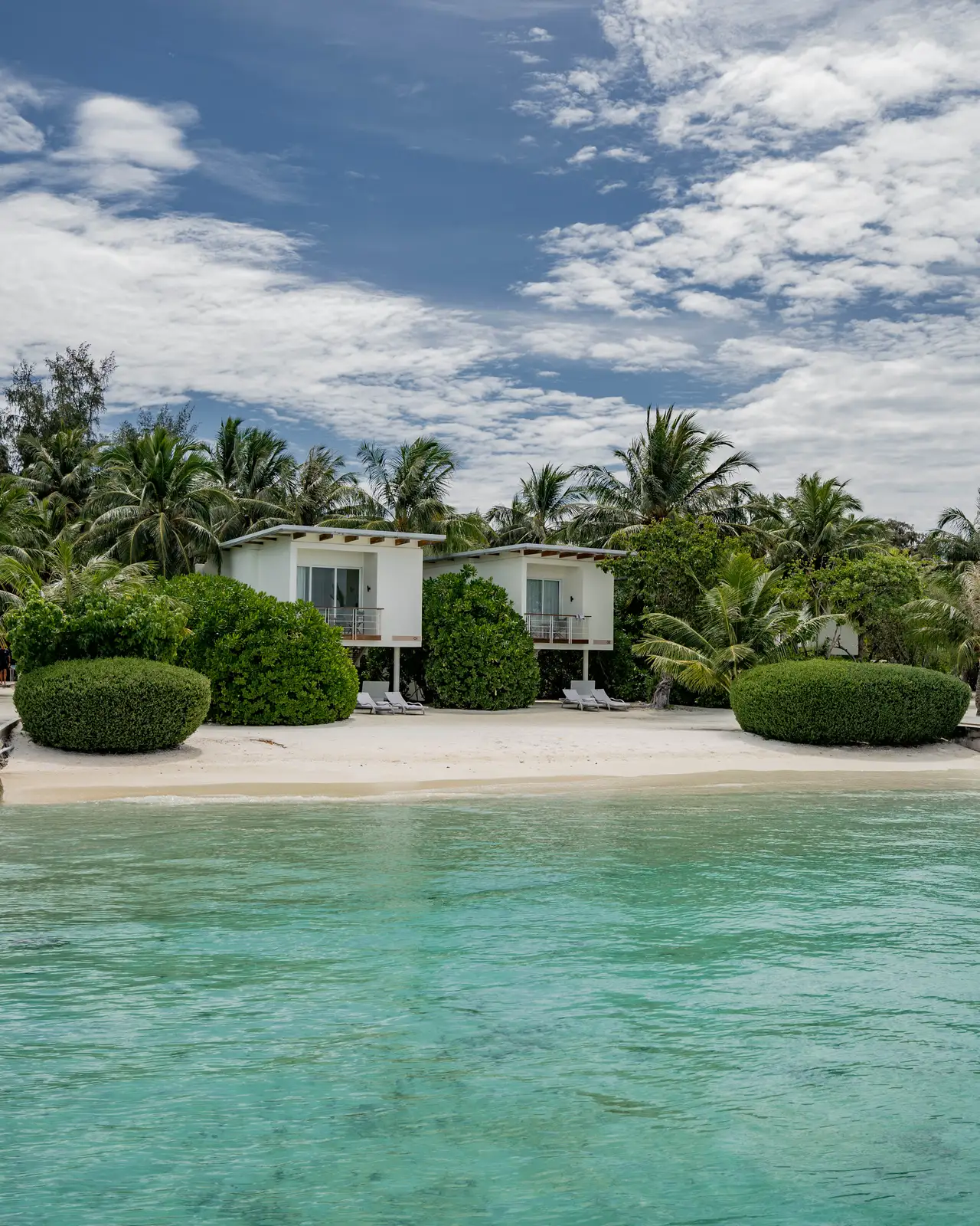 The 2-storey Beach Houses among the palms, seen from the lagoon.