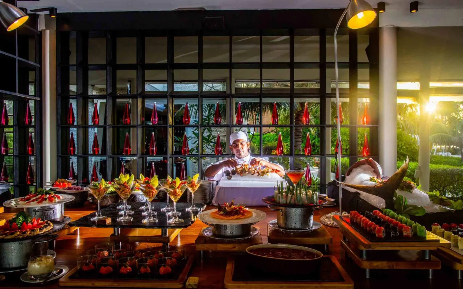 The evening buffet at Kandooma Café: a chef behind the fish and shellfish on ice, among the lamps.