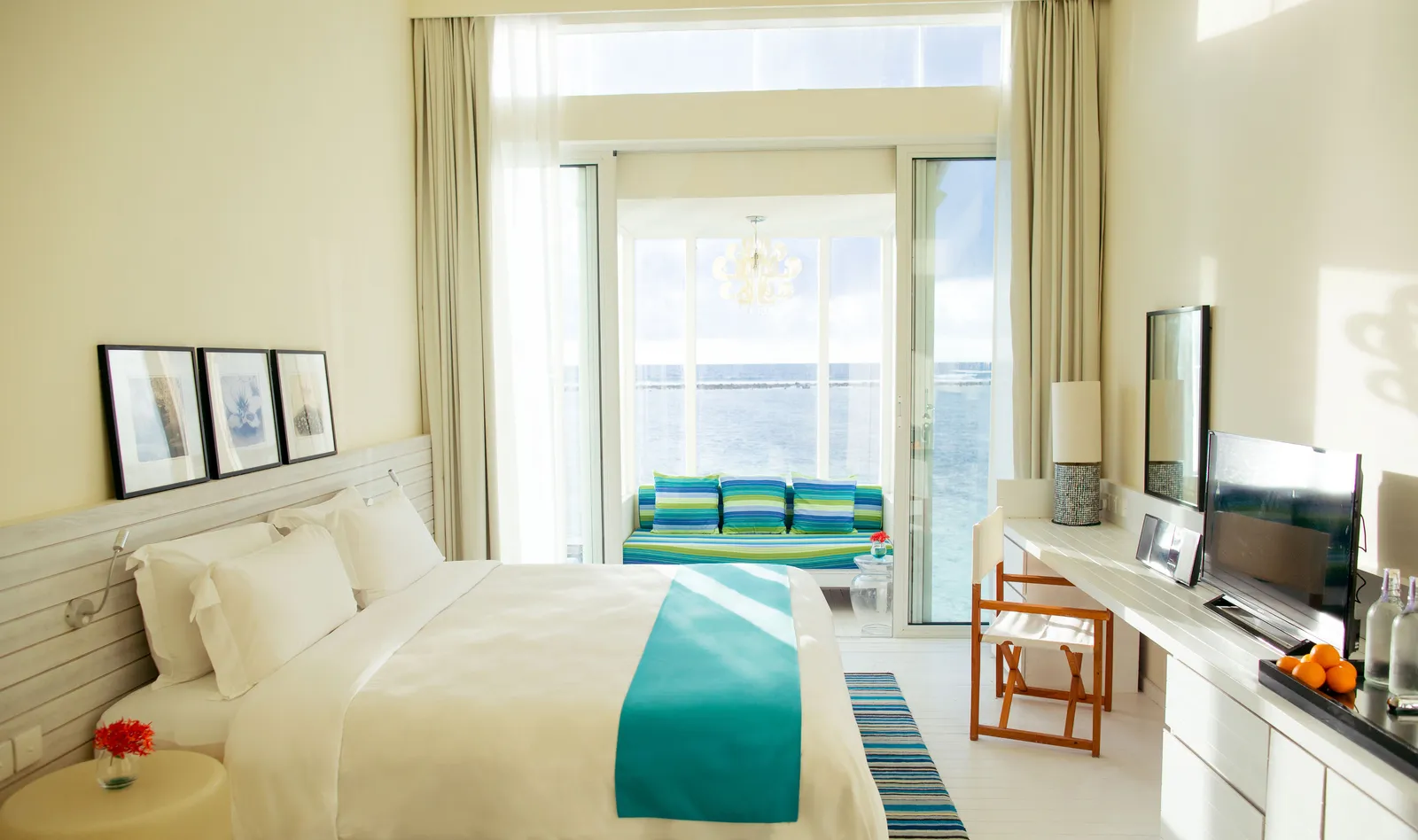 The main bedroom of the 2-bedroom water villa: the bed and the glass door onto the sea.