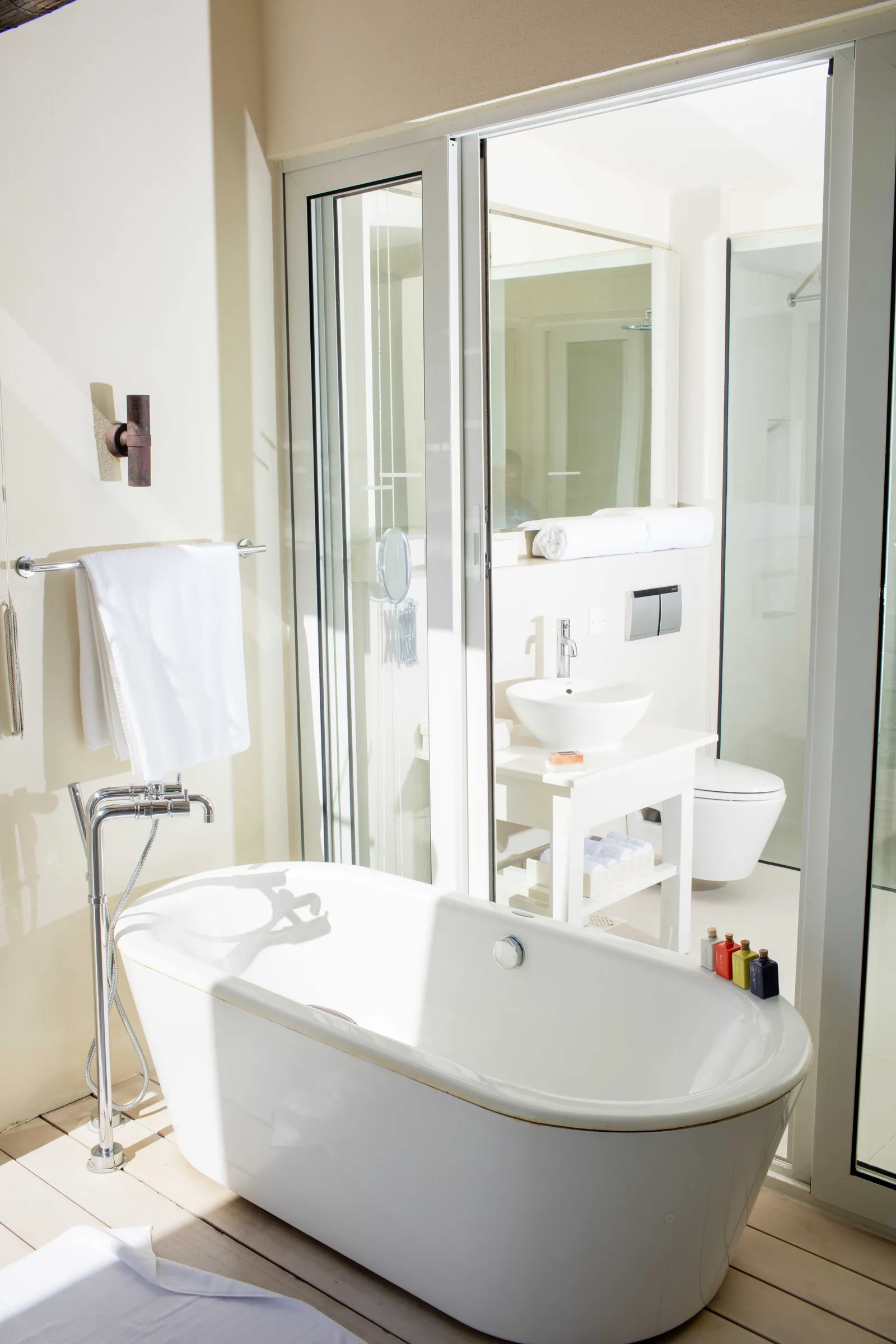 The freestanding tub in a water villa bathroom, beside the shower and the basin.