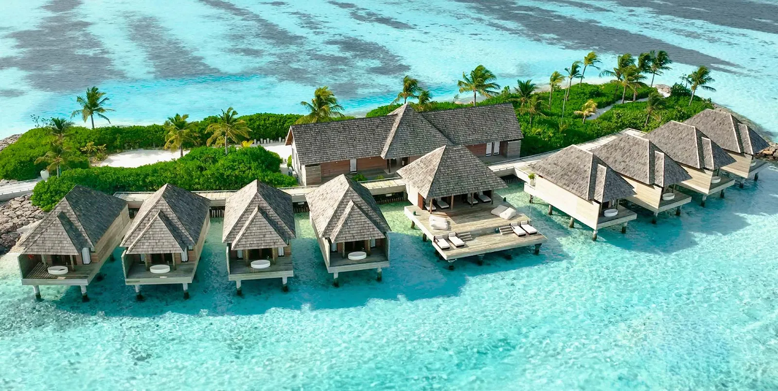 The spa's islet from above: the thatched treatment pavilions standing over the water around a small garden.