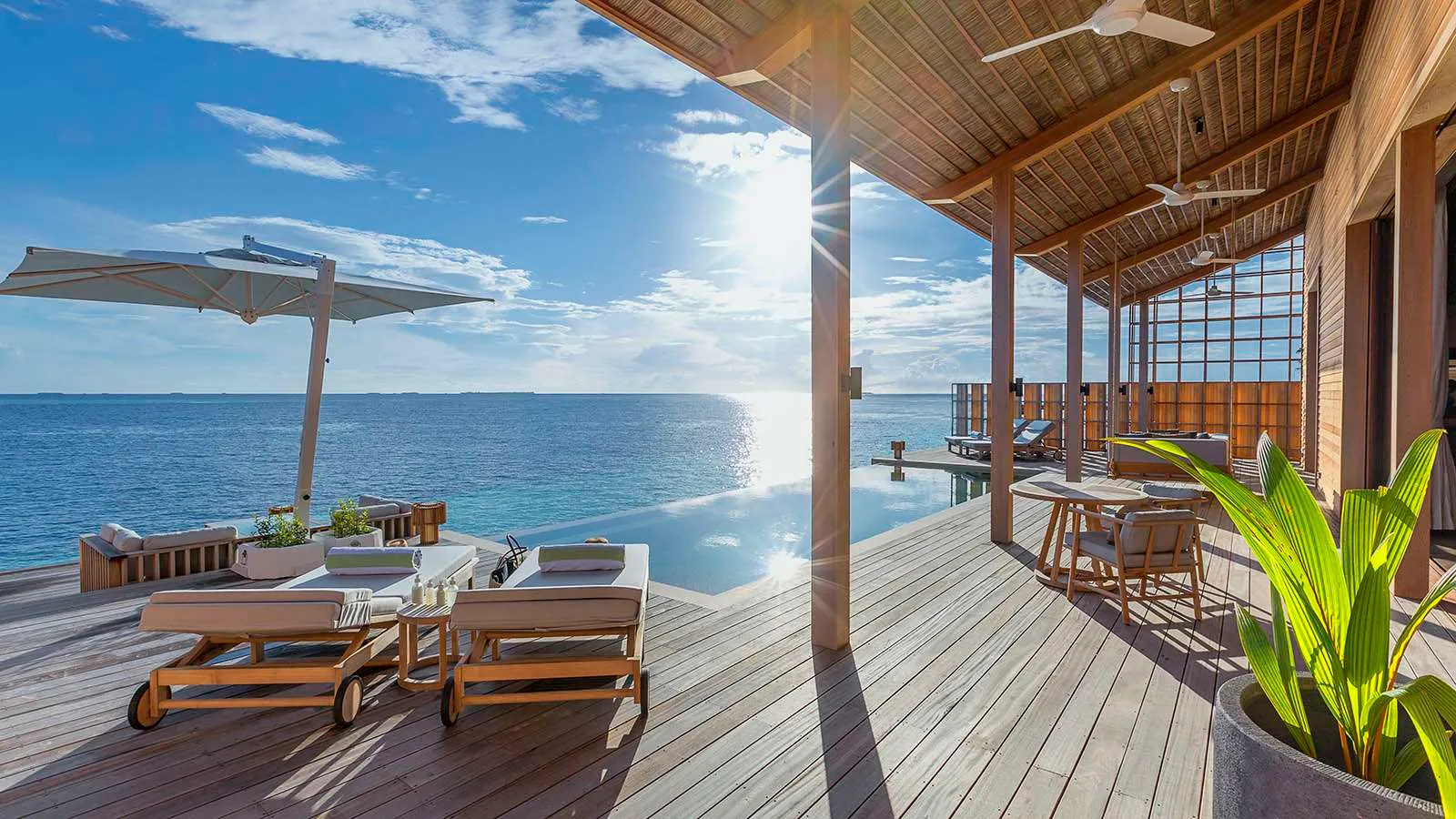 The deck of a 2-bedroom residence, its loungers and the open sea