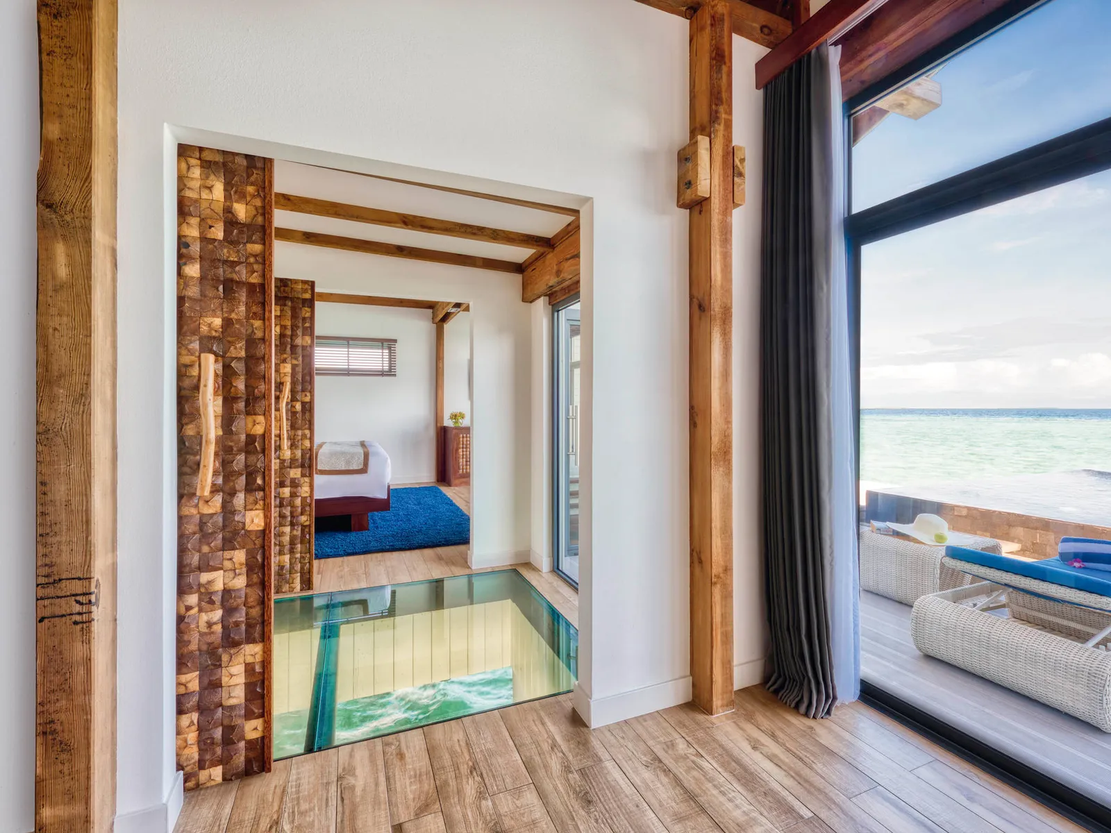 Inside an overwater villa, with the glass panel in the floor