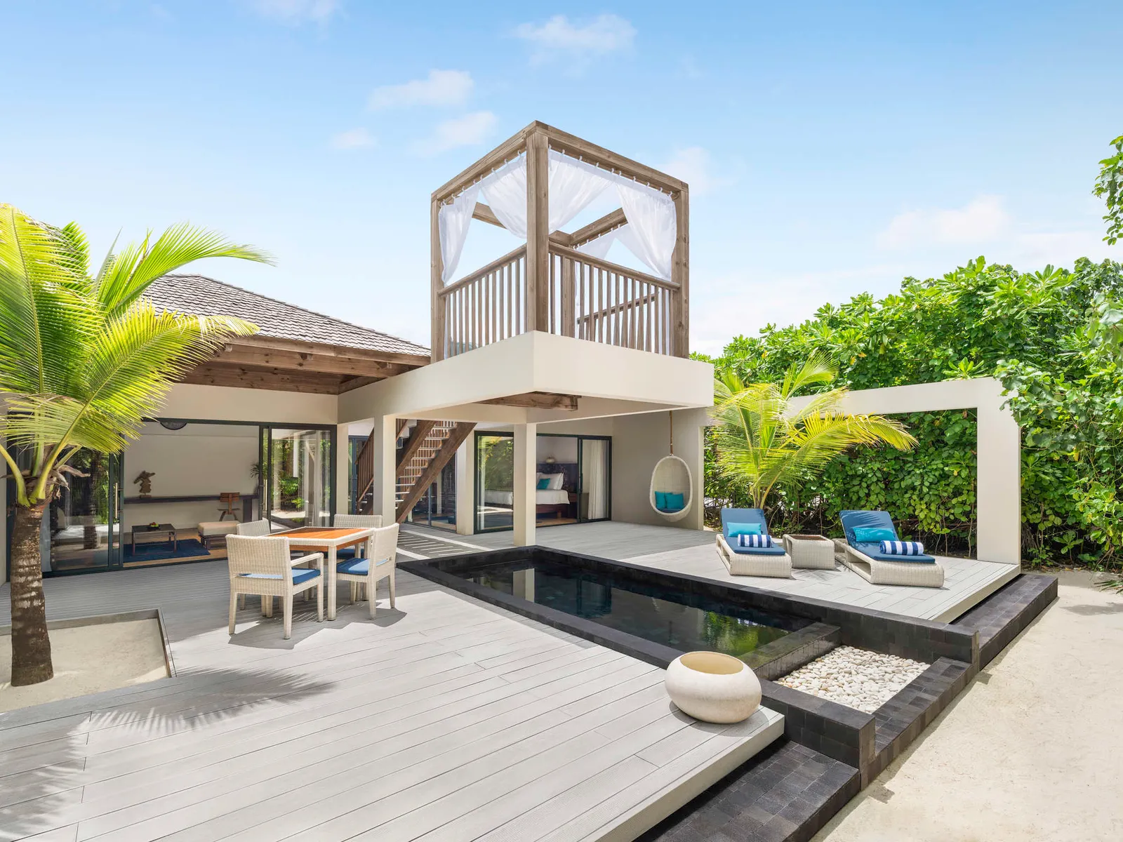 A Beach Pool Villa among the palms, its pool and loungers in front